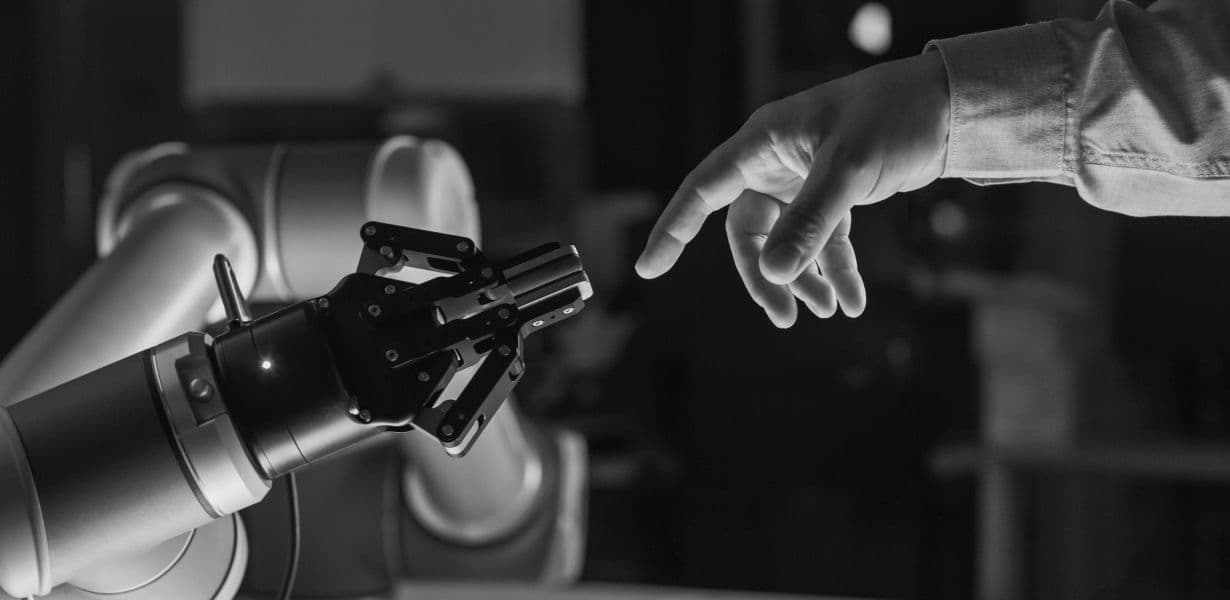 Человек, касающийся роботизированной руки